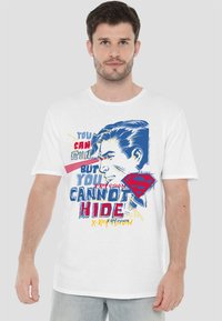 White cotton t-shirt featuring a colorful graphic design with text and an illustrated face. Notable red and blue accents, relaxed fit.
