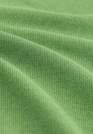 Roheline soonikuga kangas, millel on pehme tekstuur, peened, ühtlaselt jaotatud kudumis mustrid ja sujuvad lainelised voldid.