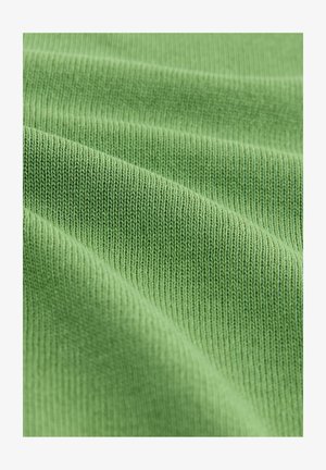 Grøn ribbet stof med en blød tekstur, der har fine, jævnt fordelt strikkemønstre og glatte, bølgende folder.