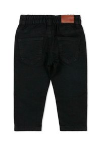 Pantalon en denim noir avec une ceinture élastique, des poches arrière cousues et une étiquette rectangulaire en cuir marron à la taille.