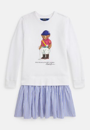 Hvit kjole med lange ermer og en stripete blå-hvit plissért skjørt, med et trykt bilde av en bjørn i polo-skjorte på fronten.