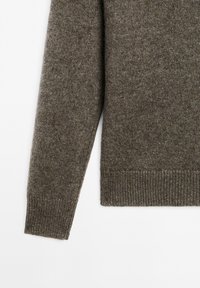 Bruine gebreide trui met mouw en onderzoom met geribde manchetten, weergegeven op een witte achtergrond.