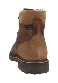 Ruskeat nahkaiset ja mokkaiset nilkkurit, joissa kestävä kumipohja, ommeltu kuviointi ja logotunnus lähellä kantapäätä.