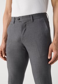 Gray tailored trousers made of smooth fabric. Features a single button closure, side pockets, and a slim fit design.