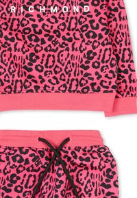 Roze luipaardprint sweatshirt en bijpassende joggers, met ribgebreide manchetten en tailleband, en een zwarte trekkoorddetail op de broek.