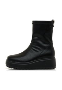 Botas de tobillo negras de cuero suave, con suela gruesa, punta redonda y costuras mínimas. Acento de cremallera en la parte trasera.