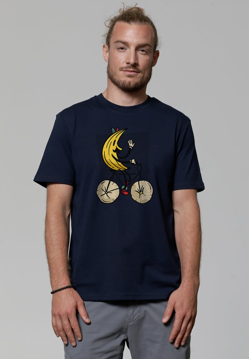 Navy katoenen t-shirt met een afbeelding van een banaan die op een fiets met gouden wielen en rode accenten rijdt, in een speelse illustratiestijl.