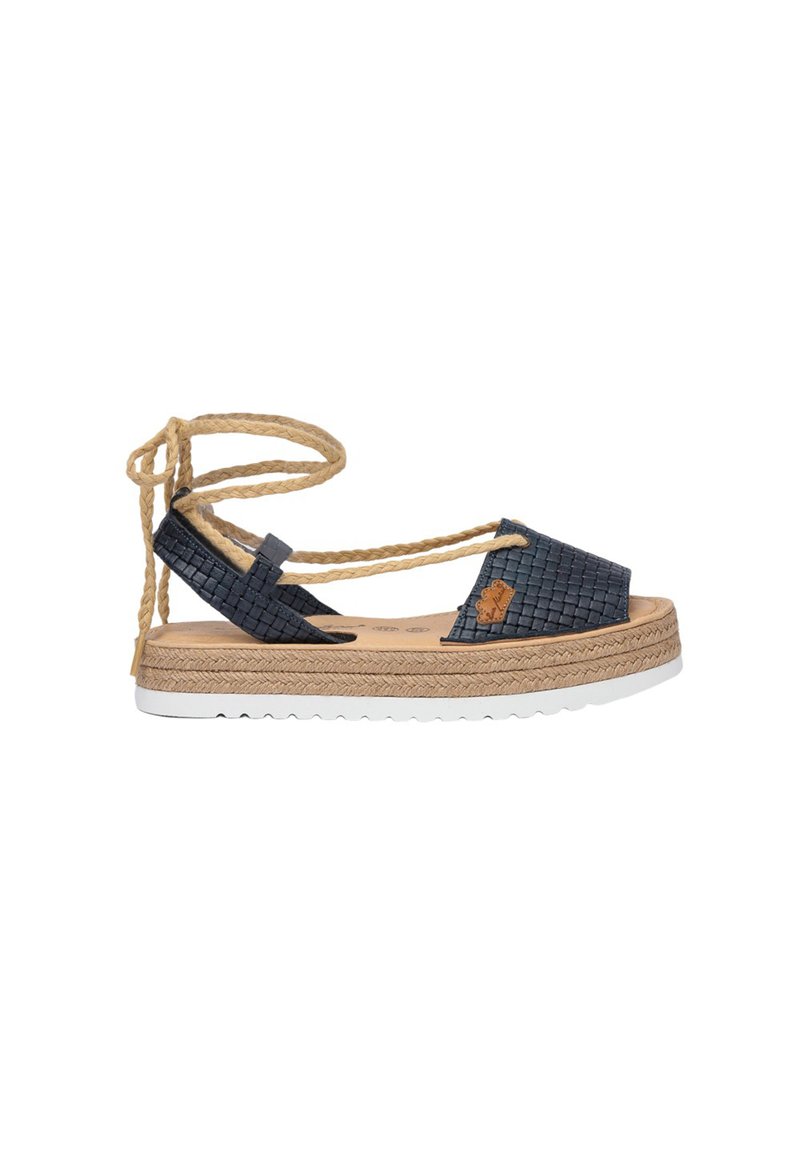 Sandalia espadrille con parte superior de nailon tejido en color azul marino, con un lazo de cuerda natural en el tobillo, plantilla de corcho y suela de plataforma envuelta en yute con suela exterior de goma blanca.