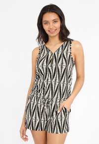 Rompers à motifs noir et blanc avec décolleté en V, détail zippé, taille élastique et poches, présentant un design de feuilles géométriques.