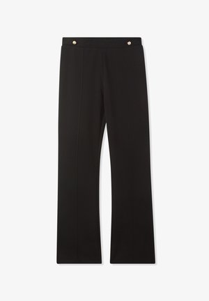 Pantaloni neri con una vestibilità slim, tessuto morbido, due pieghe frontali e dettagli metallici in vita.