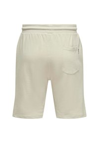 Pantalones cortos de color beige claro con una cinturilla elástica, un bolsillo de parche en el lado derecho y una textura suave y lisa.