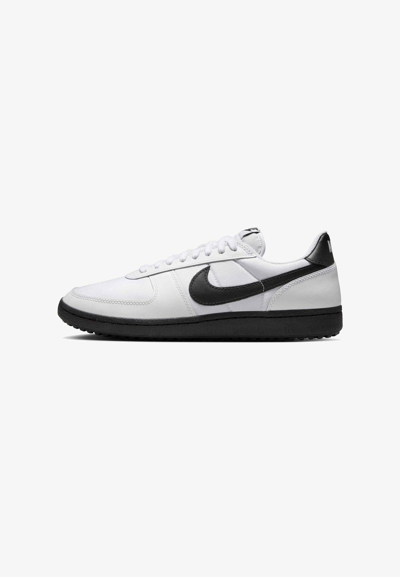 Białe sneakersy z czarnymi akcentami, z górną częścią z gładkiej skóry i teksturowaną gumową podeszwą. Sznurowadła są białe; logo jest wyraźnie widoczne.