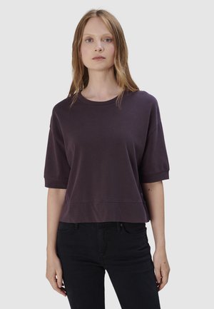 Korte mouwen, cropped sweatshirt van diep paarse katoen. Heeft een ronde halslijn, eenvoudige stiksels en een relaxte pasvorm. Gekocht bij zwarte jeans.
