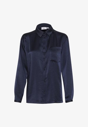 Tengerészkék selyemblúz hosszú ujjakkal, gombos elülső rész, gallér és mellzseb. Simább textúrával és enyhén fényes felülettel rendelkezik.