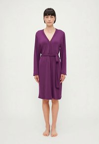 Μωβ ρόμπα με μακριά μανίκια, V-λαιμόκοψη και ζώνη που δένει μόνη της. Διαθέτει ομαλό, ελαφρύ ύφασμα και σχέδιο με μήκος έως το γόνατο.