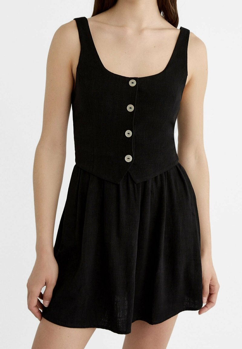 Robe en lin noir avec un corsage ajusté à encolure carrée, cinq boutons ronds, et une jupe évasée. Texture lisse, design sans manches.