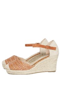 Scarpe con tacco a cuneo con una tomaia intrecciata color tan, suola in espadrille intrecciata di colore chiaro e cinturino alla caviglia. Tessuto testurizzato con motivi sottili.