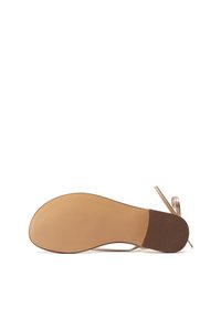 Sandalo beige con suola liscia, caratterizzato da un accento marrone texturizzato. Le cinghie sono sottili, con una finitura metallica e un dettaglio a fiocco sul retro.