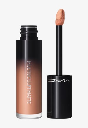 Zwart en bruin ombre vloeibare make-upbuis met het label "Multisculpt Matte" en een applicatorstift die een beige vloeibaar product toont.