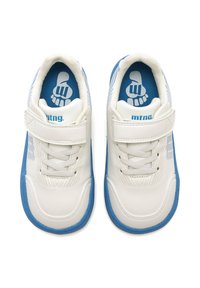 Zapatillas infantiles blancas y azules con cierres de velcro, cordones y un logo de pie en las plantillas azules, mostradas desde arriba sobre un fondo blanco.