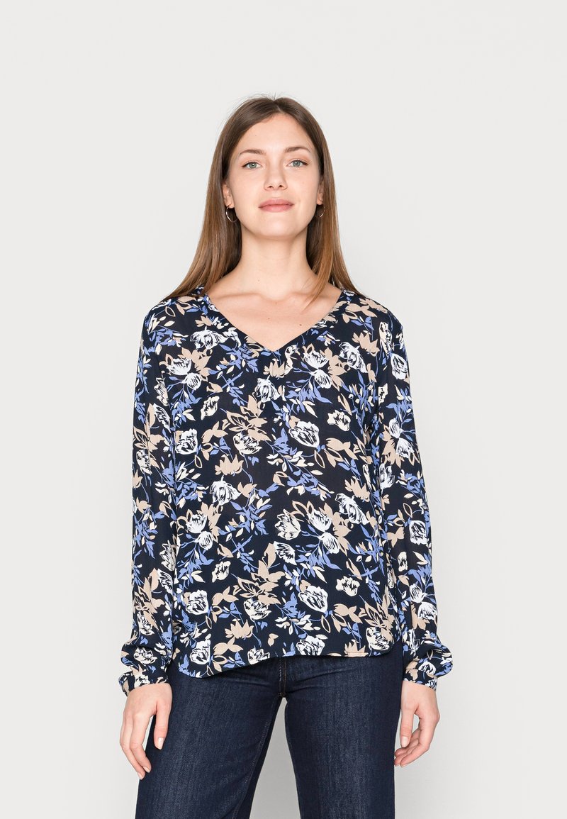 Blusa de manga longa com fundo azul-marinho e padrões florais em azul claro e bege. Decote em V com mangas franzidas, tecido suave.