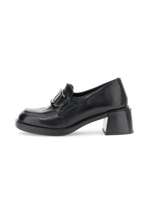 Scarpe in pelle nera con tacco a blocco e punta rotonda, caratterizzate da un'accentuazione decorativa a fibbia. Texture liscia e una leggera lucentezza sulla superficie.