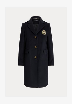 Volnen plašč temno modre barve z zarezo na ovratniku, zlatimi gumbi in grbom. Ima dva sprednja žepa in krojen silhuet.