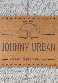 Gray woven fabric with a tan leather label. The label features embossed text: "JOHNNY URBAN," "METROPOLITAN ACCESSORIES," and "EST. 2016."