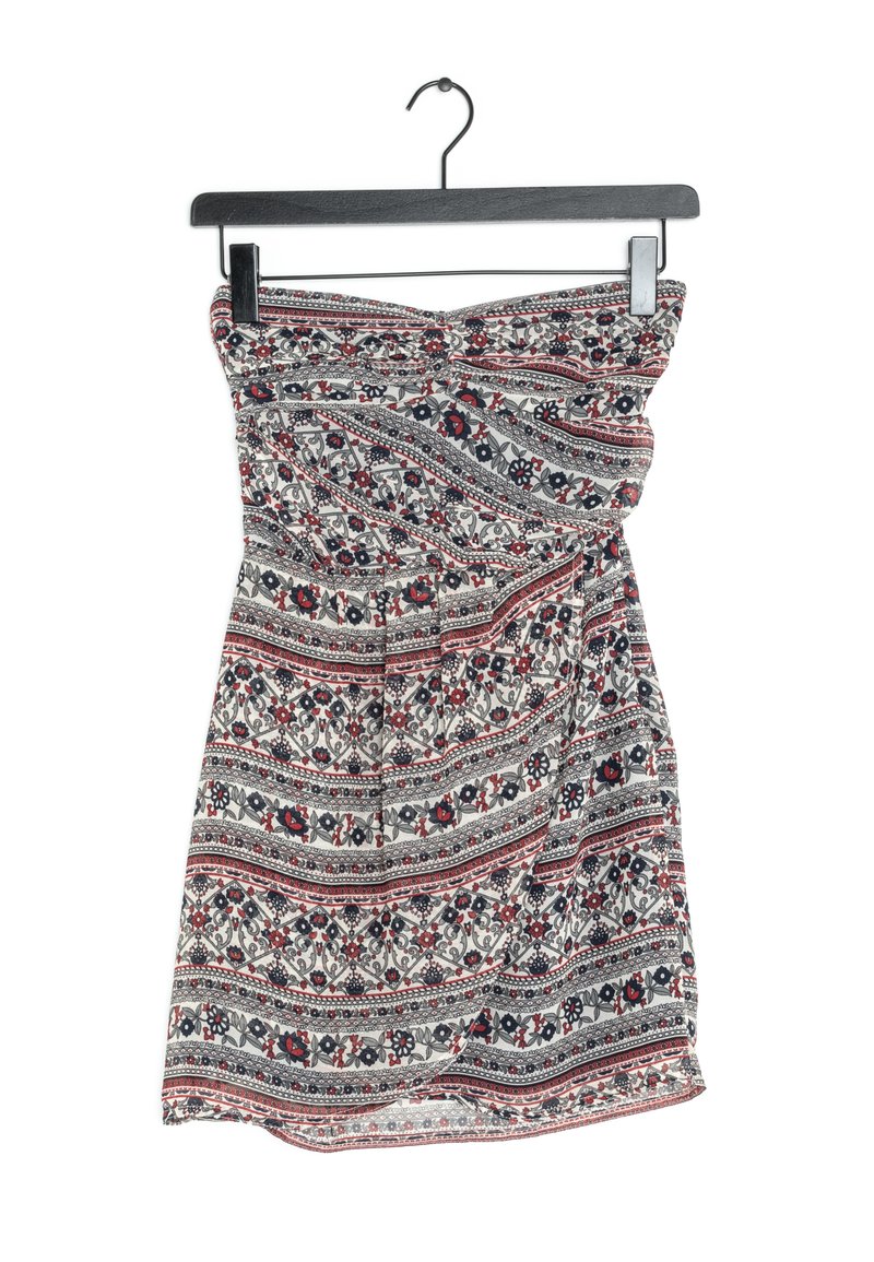 Robe sans bretelles présentant un imprimé floral et tribal en rouge, noir et blanc, avec un tissu fluide et un détail torsadé au niveau de la poitrine.