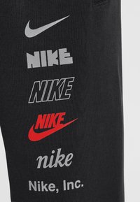 Nike Sportswear CLUB UNISEX - Treniņtērpa apakšdaļas - black/smoke grey/university red