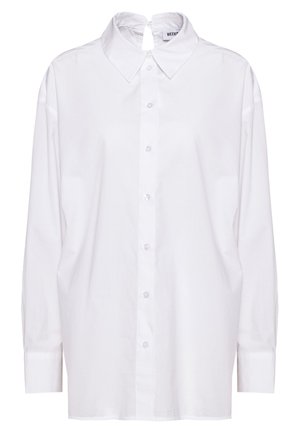 Chemise blanche à manches longues boutonnée avec col pointu et fermeture à œillet au niveau de l'encolure au dos.