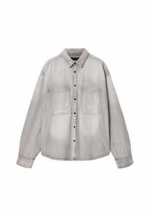 Lysegrå skjorte med knapper, lange ærmer, to store brystlommer foran og en klassisk krave, lagt fladt på en hvid baggrund.