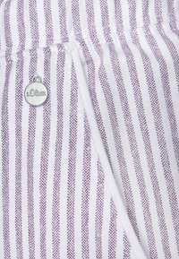 Biely textil s vertikálnymi fialovými prúžkami a malými bodkovanými vzormi, s okrúhlou striebornou značkou s embosovaným nápisom "s.Oliver".