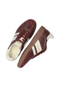 Bordowe trampki z białymi paskami, wykonane z zamszu i skóry, z wyściełanym językiem, gumową podeszwą oraz złotym detalem z logo z boku.