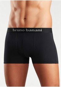 Schwarze Baumwoll-Boxershorts mit einem elastischen Bund, der gebrandet ist. Sie bieten eine enge Passform und eine glatte Textur, die für Komfort und Unterstützung ausgelegt ist.