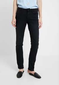 Černé skinny džíny vyrobené z denimu, s klasickým pětipocketovým designem. Tkanina vypadá hladce, s minimálním opotřebením a žádnými viditelnými vzory.