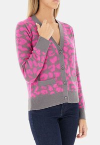 Cardigan grigio con stampa leopardata in un vivace rosa. Presenta un collo a V, chiusura con bottoni e due tasche frontali. Morbido al tatto, con polsini a coste.