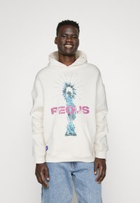 Sudadera blanca con un gráfico azul de la Estatua de la Libertad, la palabra "PEQUS" en rosa y un bolsillo frontal; corte relajado.