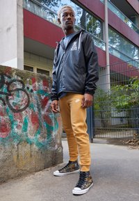 Nike Sportswear CLUB JGGR - Tracksuit bottoms - gold-coloured