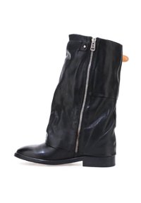 Czarne skórzane botki za kostkę o luźnym fasonie, z bocznym zamkiem, płaskim obcasem i gładką, błyszczącą fakturą. Posiadają kontrastowy akcent w kolorze brązowym.