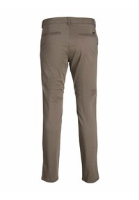 Bruna bomullsbukser med slim fit, två bakfickor med sömdetaljer och en subtil logotyp nära midjan.