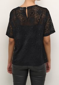 Czarny koronkowy top z kwiatowym wzorem i fakturą, z krótkimi rękawami i zapięciem z tyłu na kluczyk. Gładka podszewka.