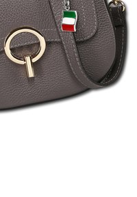Grijze leren handtas met een ronde gouden hardwareaccent en een klein Italiaans vlaghangertje. Het ontwerp heeft een gestructureerd oppervlak.