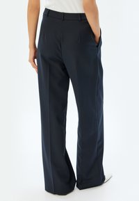 Navy wijde broek gemaakt van soepele stof, met een hoge taille, twee zijzakken en een klassieke, op maat gemaakte uitstraling.