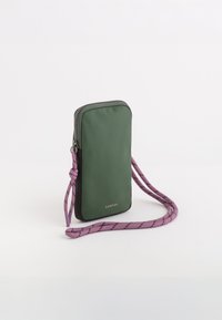 Zelená nylonová taška na telefon se zipovým uzávěrem, černými detaily a texturovaným fialovým popruhem s černými pruhy pro nastavitelnou délku nošení.