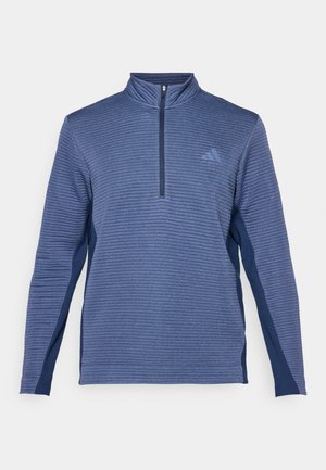 Dunkelblauer Pullover mit gerippter Textur, Halb-Reißverschluss-Kragen, langen Ärmeln und seitlichen Akzenten in einem dunkleren Blauton. Mit Logo auf der Brust.
