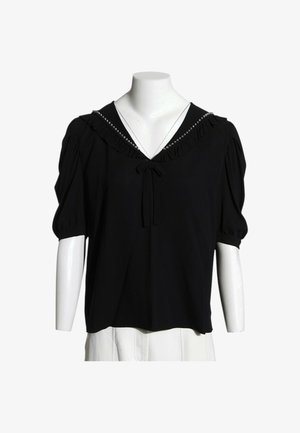 Blusa negra de manga corta con escote en V acanalado y pequeño lazo en el centro, exhibida en torso de maniquí blanco.