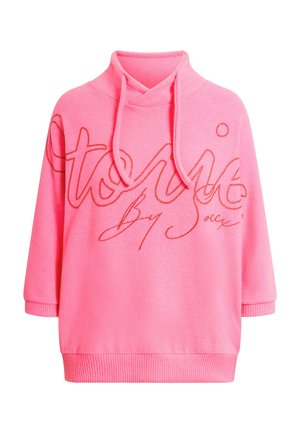Bright pink hoodie with ribbed cuffs and hem, featuring large cursive text across the chest and adjustable drawstrings at the neck.