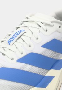 Scarpa da corsa Adidas Adizero bianca e blu con lacci bianchi e tre strisce blu sul lato.