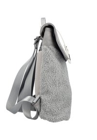 Sac à dos gris avec panneau latéral en polaire texturée, sangles réglables, dos en mesh et fermeture à rabat avec boucle blanche, montré en vue de côté sur fond blanc.